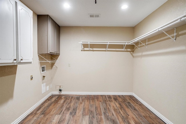 laundry room featuring electric dryer hookup, hookup for a washing machine, dark wood-type flooring, and cabinets