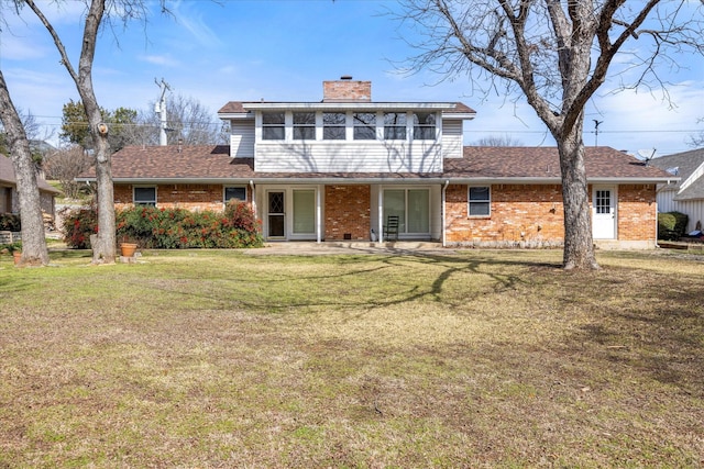 view of front of house with a sunroom, a front yard, and a patio area