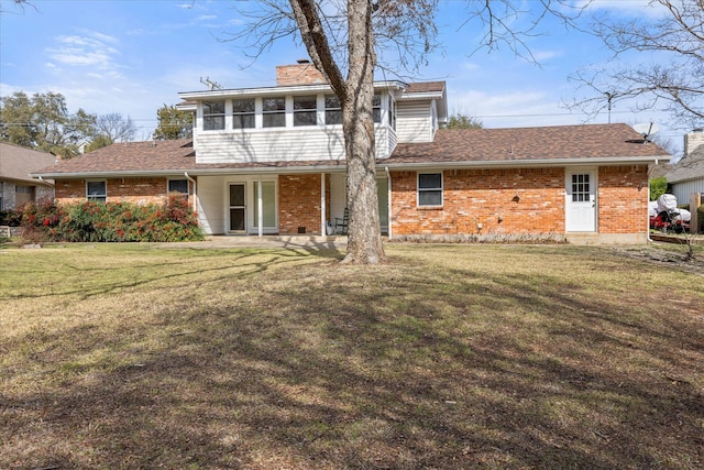 rear view of house with a sunroom, a patio area, and a lawn