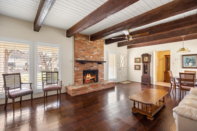 living room with beam ceiling, ceiling fan, a fireplace, and dark hardwood / wood-style flooring