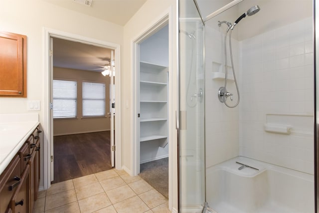 bathroom featuring tile patterned flooring, vanity, ceiling fan, and walk in shower