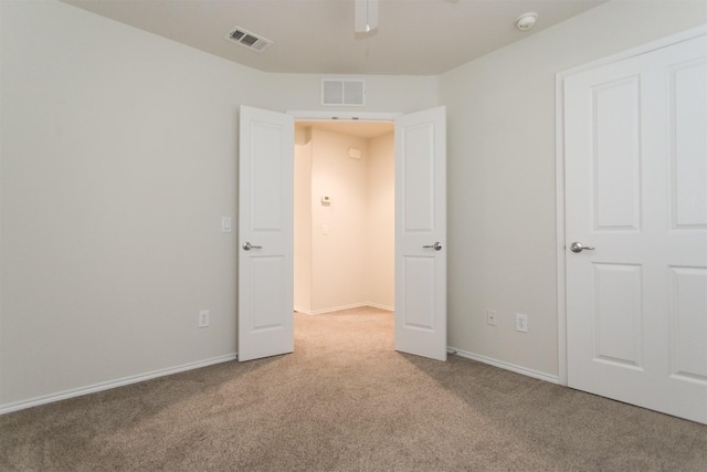 carpeted spare room with ceiling fan