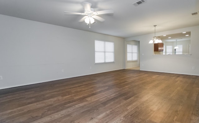 spare room featuring dark hardwood / wood-style flooring and ceiling fan with notable chandelier