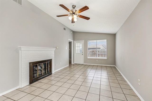 unfurnished living room featuring ceiling fan, lofted ceiling, a fireplace, and light tile patterned floors