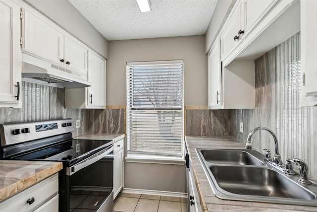 kitchen with electric stove, sink, light tile patterned floors, white cabinetry, and a textured ceiling