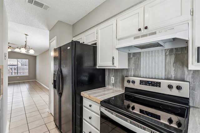 kitchen with light tile patterned floors, electric range, white cabinets, black fridge, and decorative light fixtures