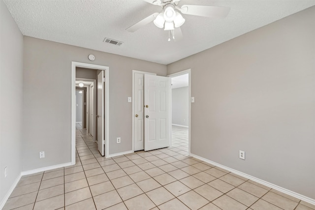 unfurnished bedroom with ceiling fan, a textured ceiling, and light tile patterned floors