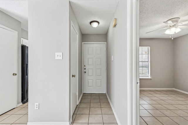 hallway featuring light tile patterned floors and a textured ceiling