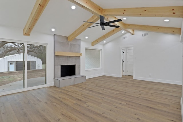 unfurnished living room featuring high vaulted ceiling, light wood-type flooring, beamed ceiling, ceiling fan, and a fireplace