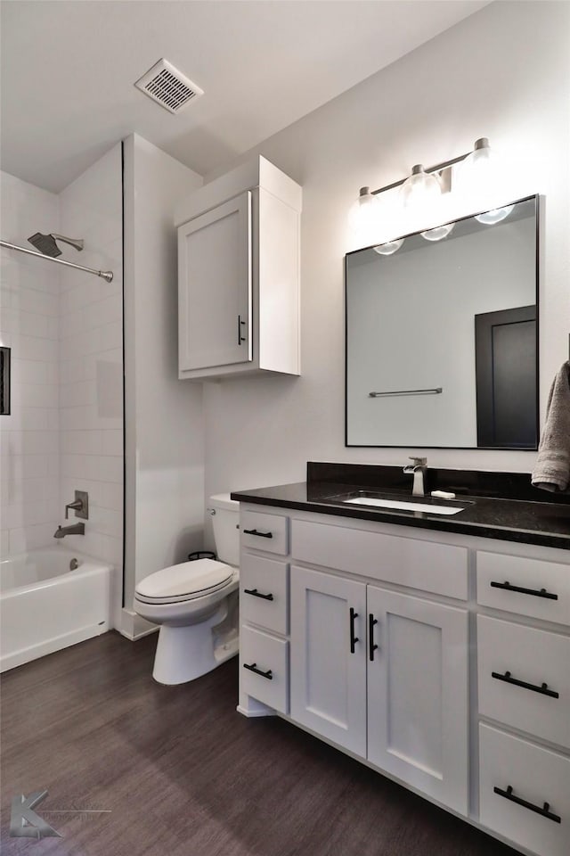 full bathroom with vanity, wood-type flooring, toilet, and tiled shower / bath