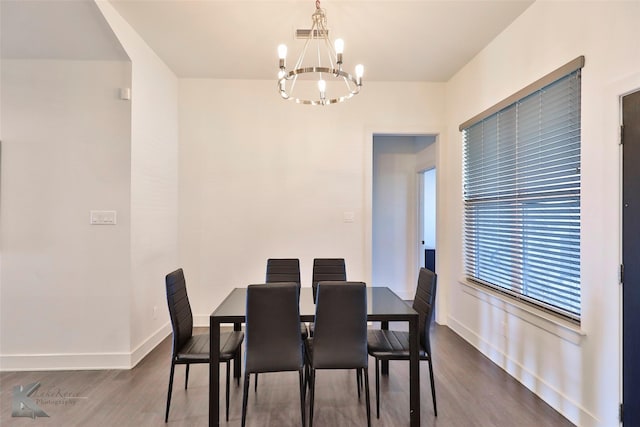 dining area featuring hardwood / wood-style floors and a notable chandelier