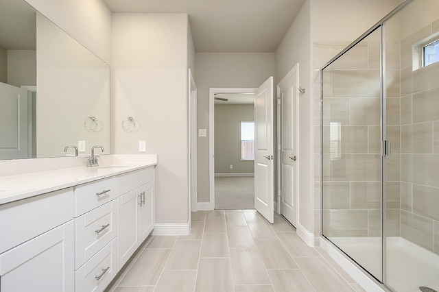 bathroom featuring vanity, a wealth of natural light, and a shower with shower door