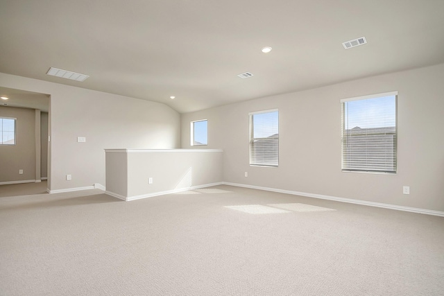 empty room with light carpet and lofted ceiling