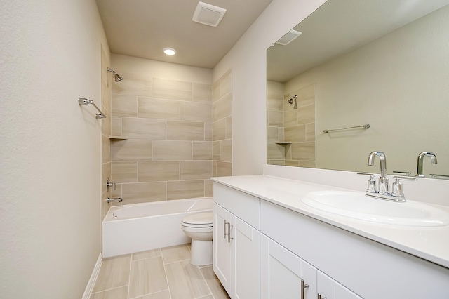 full bathroom featuring tiled shower / bath combo, vanity, tile patterned floors, and toilet