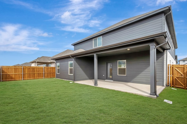 rear view of property featuring a lawn and a patio