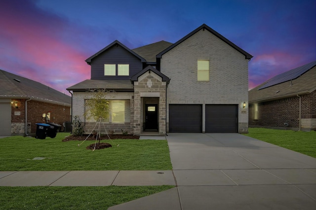 view of front of property with a garage, a yard, and central air condition unit