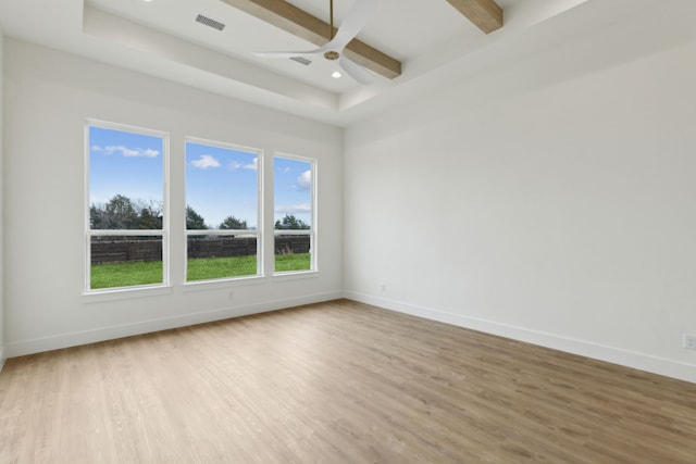 spare room with beamed ceiling, ceiling fan, and light hardwood / wood-style flooring