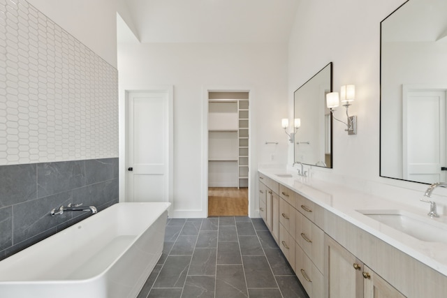 bathroom featuring a tub to relax in, tile patterned flooring, and vanity