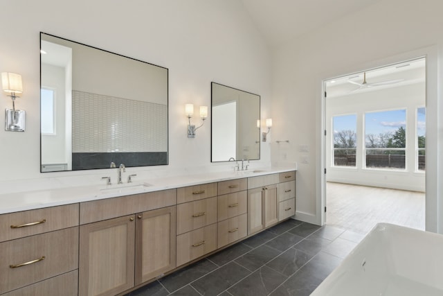 bathroom featuring lofted ceiling, vanity, and a washtub