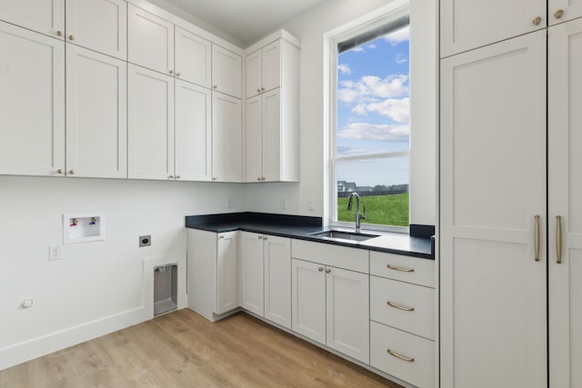 laundry room with sink, light hardwood / wood-style flooring, cabinets, washer hookup, and hookup for an electric dryer