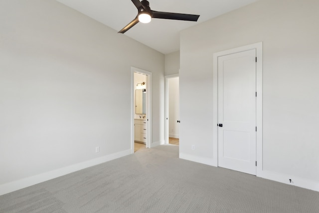 unfurnished bedroom with ceiling fan, light colored carpet, and connected bathroom