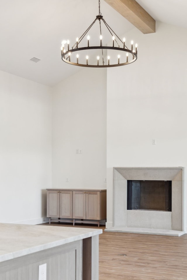 details featuring beam ceiling, wood finished floors, and a fireplace