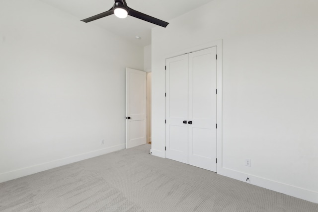 unfurnished bedroom with light colored carpet, a closet, and ceiling fan