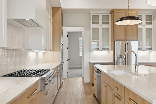 kitchen with pendant lighting, custom range hood, sink, and light brown cabinetry