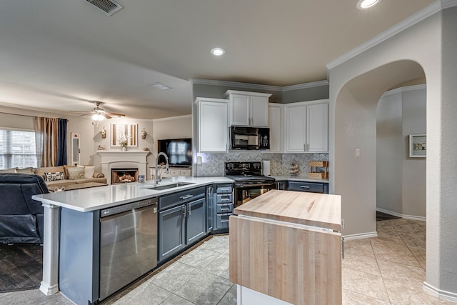 kitchen featuring white cabinetry, black appliances, sink, ornamental molding, and tasteful backsplash