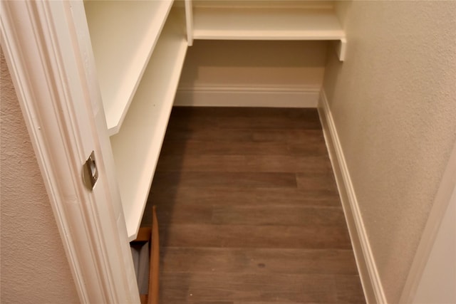 spacious closet with dark hardwood / wood-style flooring