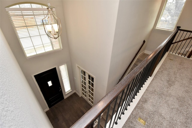 entrance foyer with a healthy amount of sunlight, a high ceiling, carpet, and a notable chandelier