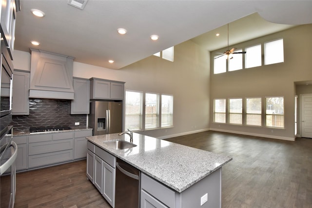 kitchen featuring stainless steel appliances, gray cabinets, sink, and custom exhaust hood