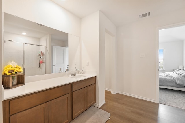 bathroom with a shower with door, vanity, and hardwood / wood-style floors