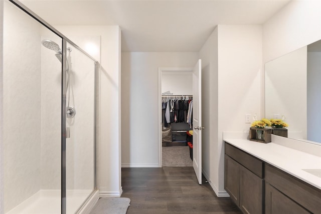 bathroom featuring hardwood / wood-style flooring, vanity, and walk in shower