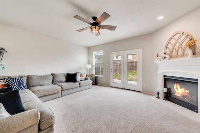 carpeted living area featuring baseboards, ceiling fan, a fireplace with flush hearth, and recessed lighting