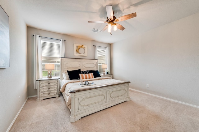 bedroom with a ceiling fan, light carpet, baseboards, and visible vents