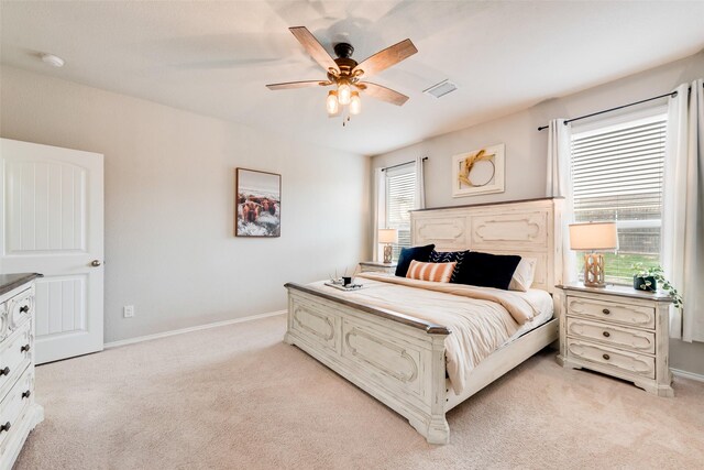 bedroom featuring baseboards, ceiling fan, visible vents, and light colored carpet