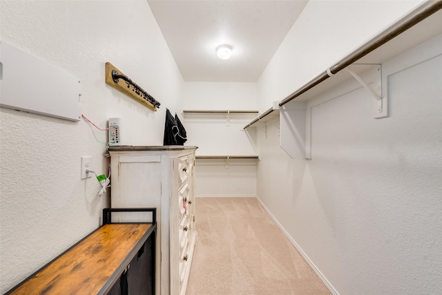walk in closet featuring light colored carpet