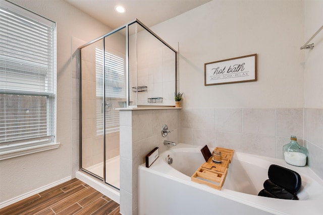 bathroom with a bath, a stall shower, recessed lighting, and wood finish floors