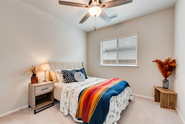 bedroom with baseboards, visible vents, a ceiling fan, and light carpet