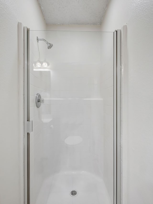 bathroom featuring walk in shower and a textured ceiling