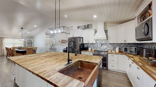1004 Rs County Road 3345, Emory, TX 75440 - kitchen with white cabinetry, wooden counters, stainless steel appliances, and custom range hood