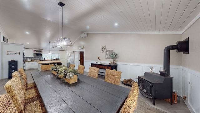 1004 Rs County Road 3345, Emory, TX 75440 - dining space featuring vaulted ceiling, a wood stove, light hardwood / wood-style floors, crown molding, and wooden ceiling