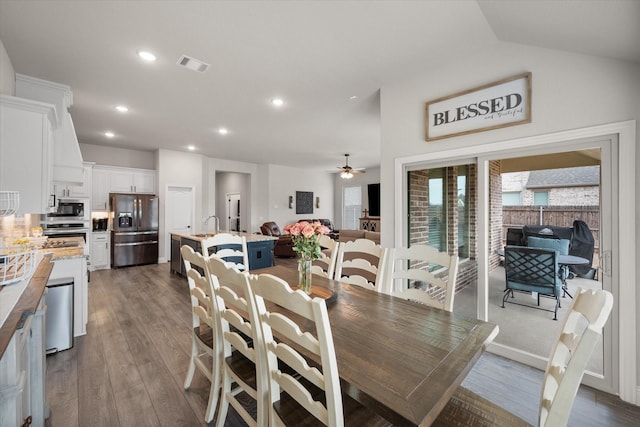 dining space featuring vaulted ceiling, dark wood-type flooring, sink, and ceiling fan