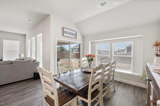 dining area featuring dark hardwood / wood-style flooring and vaulted ceiling