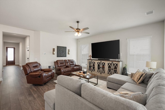 living room featuring dark wood-type flooring and ceiling fan