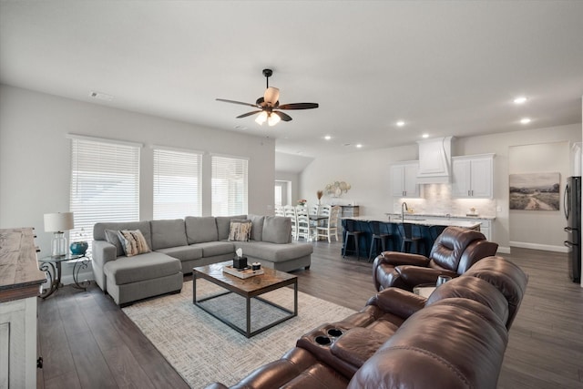 living room featuring sink, dark wood-type flooring, and ceiling fan