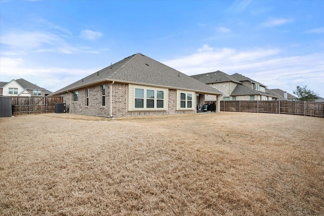 back of house with a lawn and central air condition unit