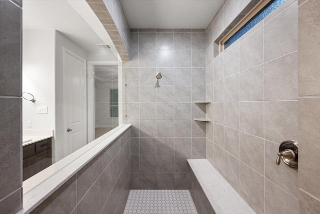 bathroom with vanity and tiled shower