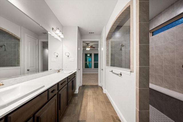 bathroom featuring vanity, tiled shower, hardwood / wood-style floors, and ceiling fan